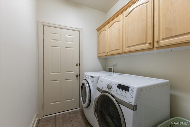 laundry room with cabinet space, separate washer and dryer, and dark tile patterned floors