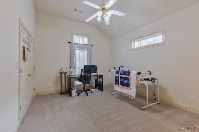 carpeted office space featuring visible vents, baseboards, lofted ceiling, and ceiling fan