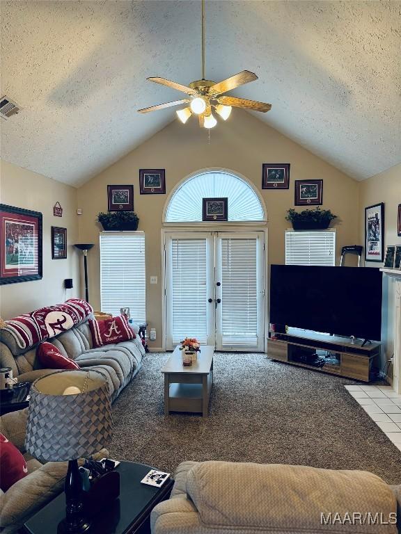 living area featuring visible vents, lofted ceiling, and a textured ceiling