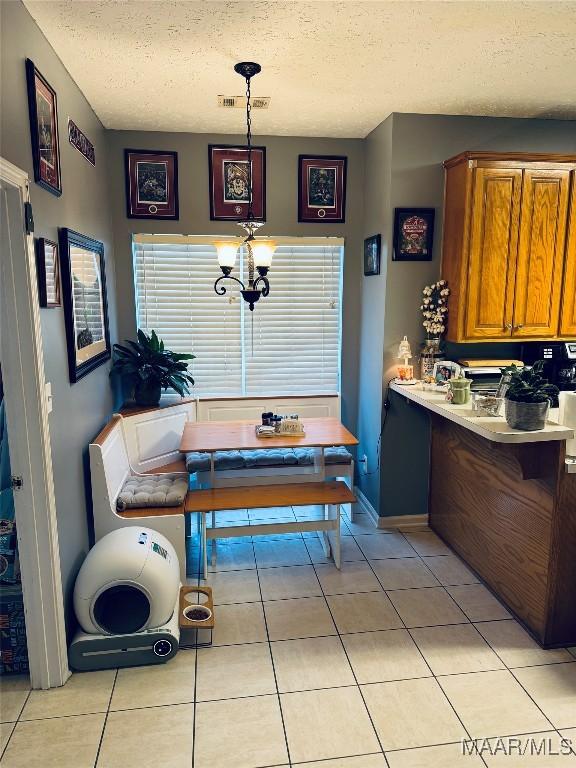 dining area with light tile patterned floors, a textured ceiling, and breakfast area