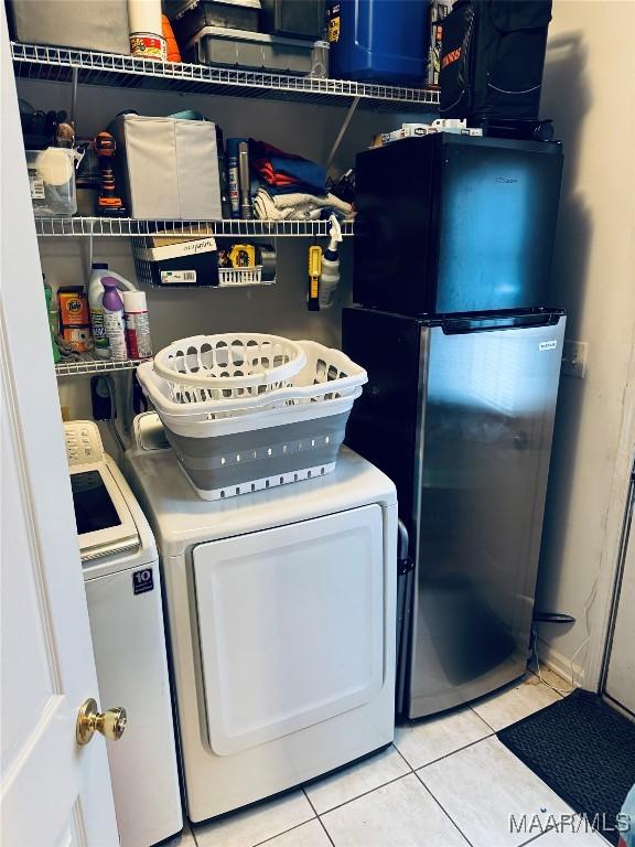 laundry area featuring light tile patterned floors, laundry area, and washer and dryer