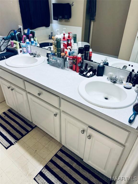 full bathroom with a sink and double vanity