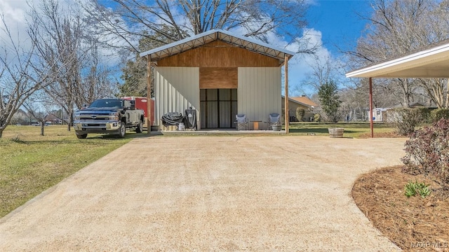 view of pole building featuring driveway and a yard