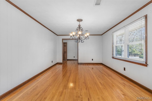 unfurnished room featuring baseboards, visible vents, light wood finished floors, ornamental molding, and a chandelier