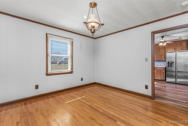 spare room featuring light wood-type flooring and ornamental molding