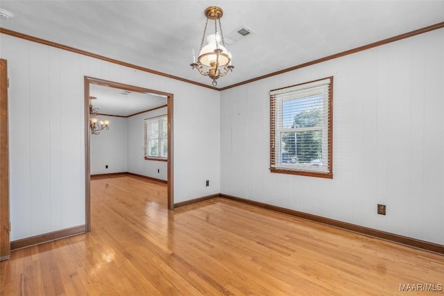 unfurnished room featuring visible vents, crown molding, light wood finished floors, baseboards, and a chandelier