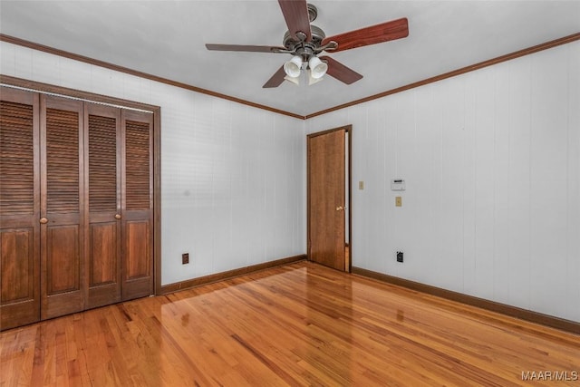 unfurnished bedroom with ceiling fan, baseboards, light wood-style floors, and ornamental molding