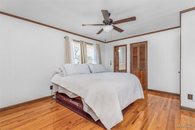 bedroom with light wood finished floors, crown molding, and baseboards