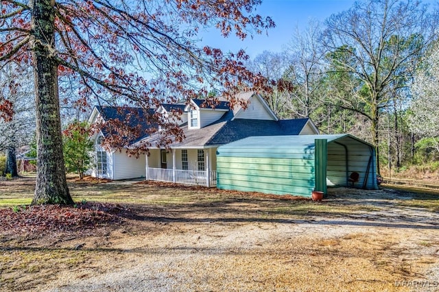 view of front of house featuring a carport, covered porch, and dirt driveway