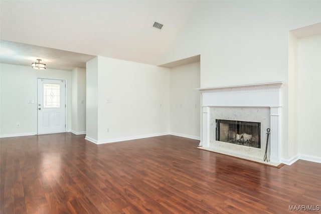 unfurnished living room featuring visible vents, a fireplace, baseboards, and wood finished floors