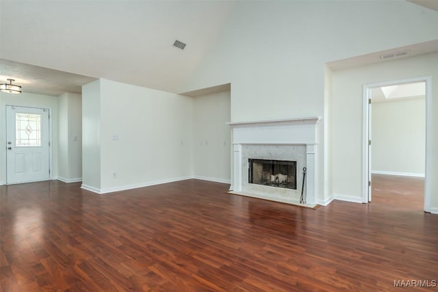 unfurnished living room featuring visible vents, baseboards, wood finished floors, and a fireplace