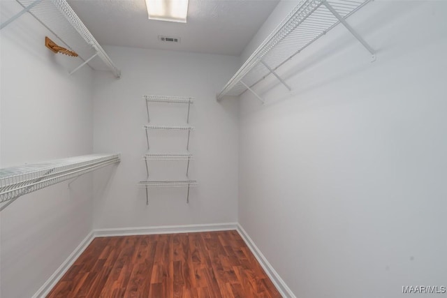 spacious closet with visible vents and dark wood-style floors