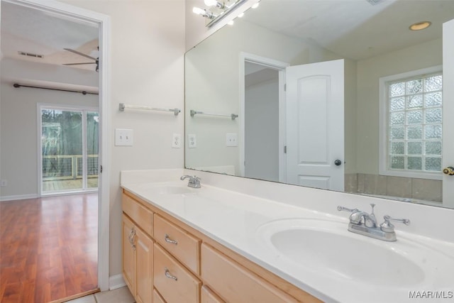 bathroom featuring double vanity, baseboards, visible vents, and a sink