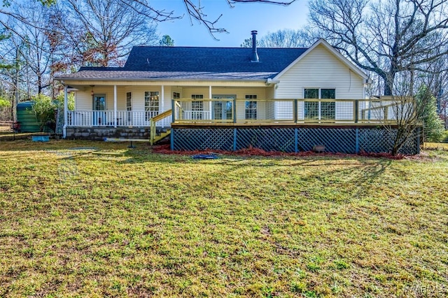 back of house featuring a yard, covered porch, and a shingled roof