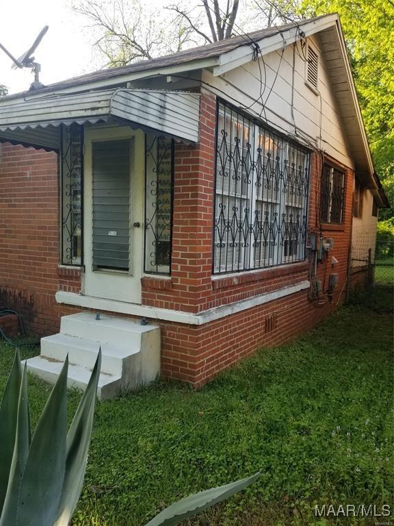 view of side of home featuring brick siding and crawl space