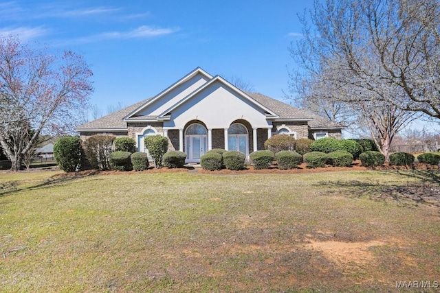 ranch-style home with french doors, a front lawn, and stucco siding