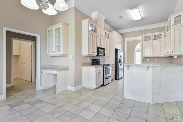 kitchen featuring light tile patterned floors, ornamental molding, glass insert cabinets, appliances with stainless steel finishes, and a kitchen breakfast bar