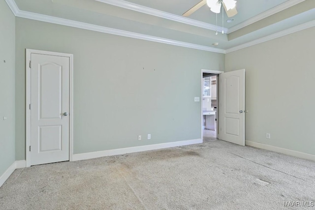 spare room featuring crown molding, carpet flooring, baseboards, and a tray ceiling