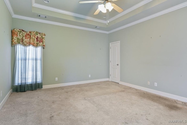 unfurnished room with carpet, a tray ceiling, crown molding, and visible vents