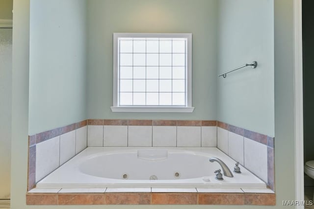 bathroom featuring toilet and a whirlpool tub