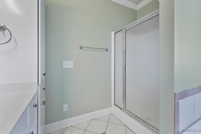 bathroom with tile patterned flooring, baseboards, a stall shower, and ornamental molding