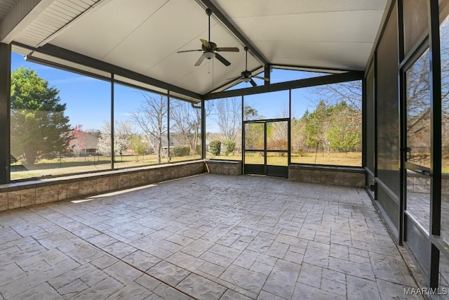 unfurnished sunroom featuring plenty of natural light, vaulted ceiling with beams, and ceiling fan