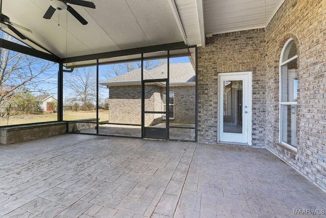 unfurnished sunroom with a ceiling fan and lofted ceiling