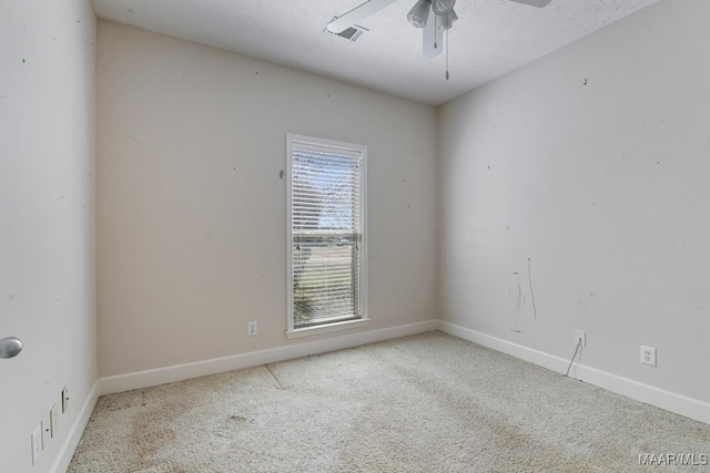 empty room featuring visible vents, baseboards, carpet, and a ceiling fan