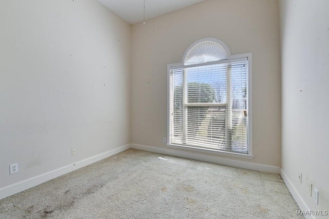 carpeted spare room with baseboards and a healthy amount of sunlight