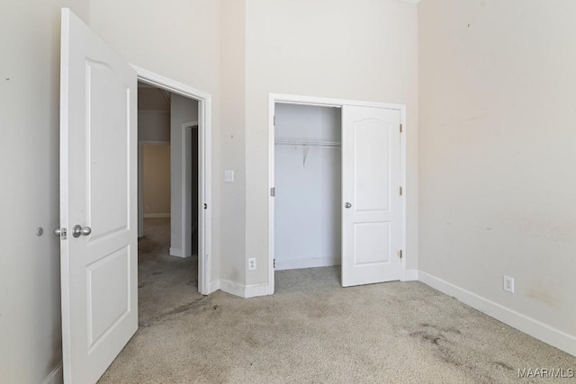 unfurnished bedroom featuring a closet, baseboards, and carpet flooring