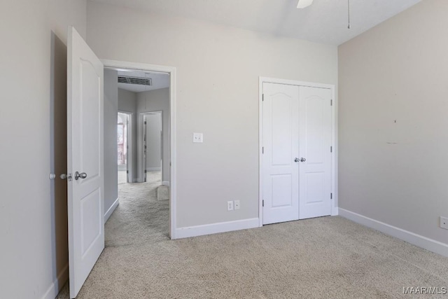 unfurnished bedroom with a closet, baseboards, visible vents, and carpet floors