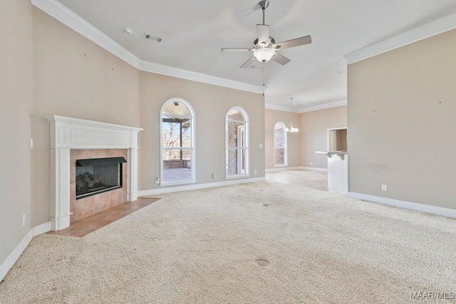 unfurnished living room with visible vents, ceiling fan with notable chandelier, baseboards, light colored carpet, and a tile fireplace