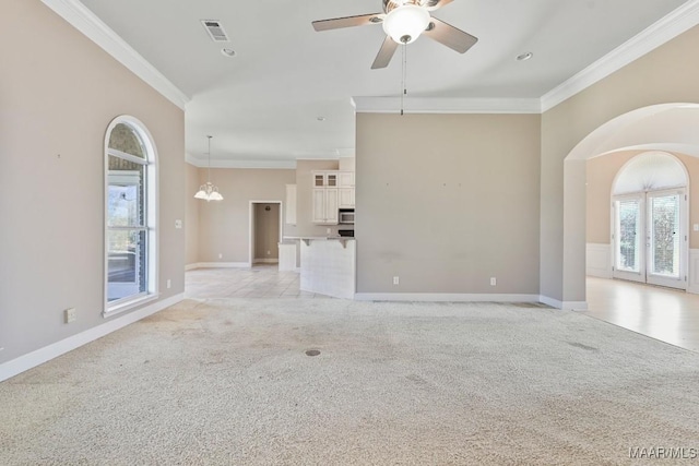 unfurnished living room with crown molding, baseboards, visible vents, and light carpet