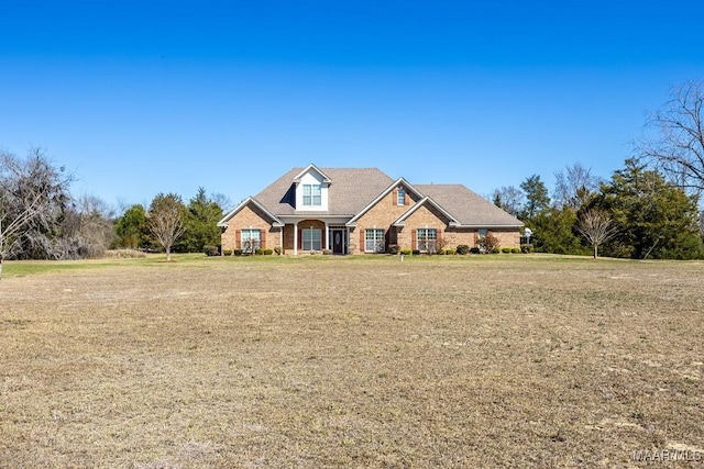 traditional-style home featuring a front yard and brick siding