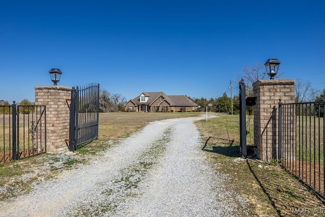 view of road with a gated entry, gravel driveway, and a gate