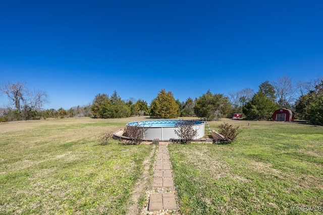 view of yard featuring an outdoor pool, an outdoor structure, and a shed