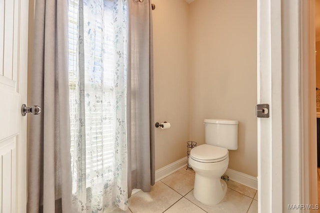 bathroom with tile patterned floors, baseboards, and toilet