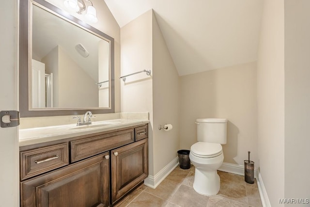 bathroom with toilet, vanity, baseboards, and vaulted ceiling