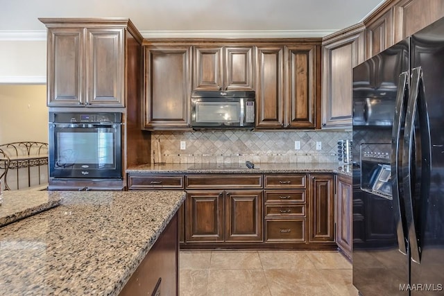 kitchen featuring decorative backsplash, black appliances, light stone counters, and crown molding