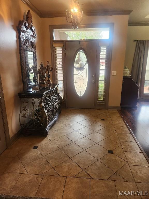 tiled entrance foyer with baseboards, a healthy amount of sunlight, and ornamental molding