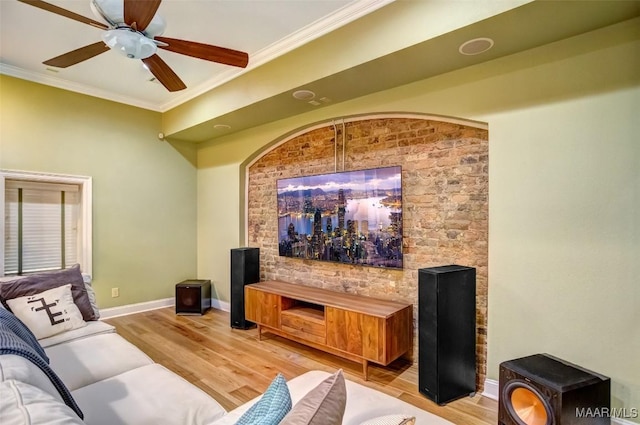 living area featuring light wood-style flooring, crown molding, and baseboards