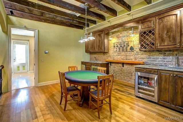 rec room with beverage cooler, beamed ceiling, light wood-style flooring, and indoor wet bar