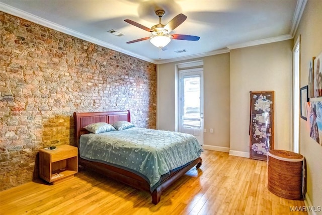 bedroom with visible vents, crown molding, baseboards, and wood finished floors