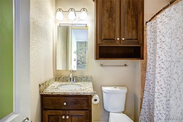 bathroom featuring vanity, curtained shower, and toilet