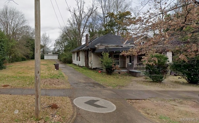 view of front of house with a front lawn, a porch, and a chimney