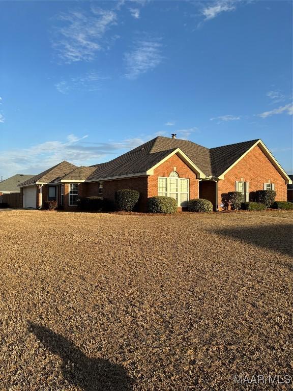 view of front of property with brick siding and a garage