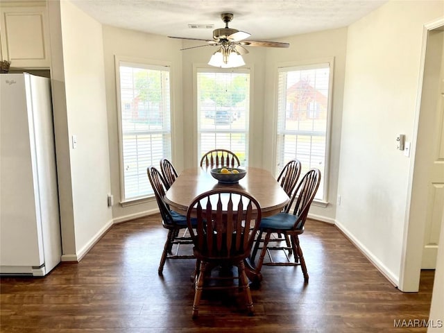 dining room with ceiling fan, dark wood-style flooring, and baseboards
