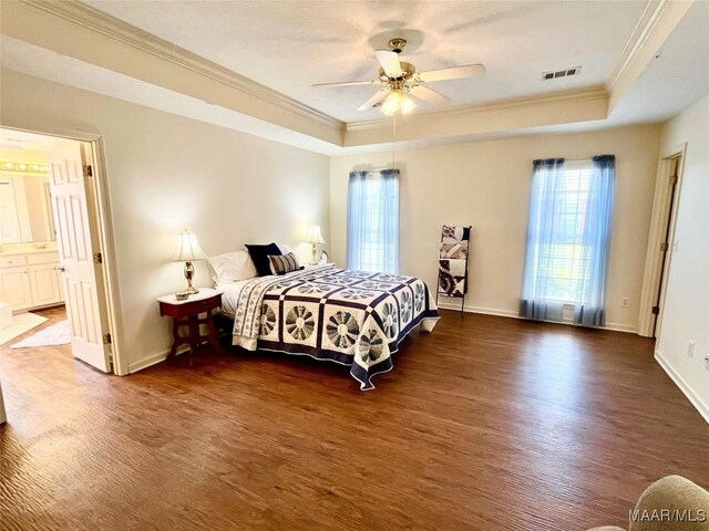 bedroom with a raised ceiling, crown molding, wood finished floors, baseboards, and a ceiling fan