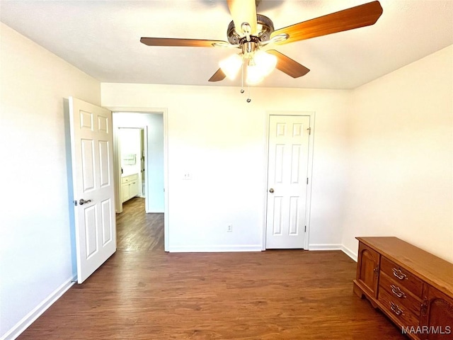 unfurnished bedroom featuring dark wood-type flooring, baseboards, and a ceiling fan