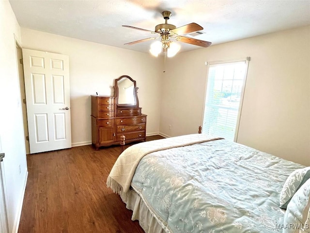bedroom featuring dark wood-style flooring, a ceiling fan, and baseboards